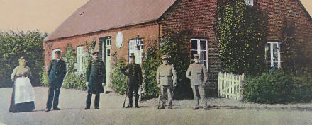 Grænsegendarmer i lyseblå uniformer og toldere i sorte uniformer foran gården Blokager i Kalvslund, der havde dansk toldsted indtil 1920. Foto: Kalvslund Lokalarkiv.